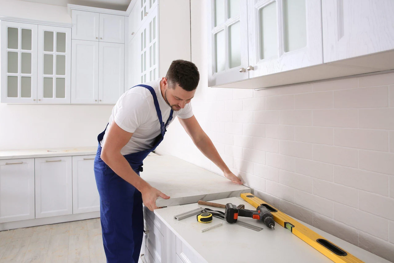 Contractor installing kitchen countertop to avoid kitchen remodel delays during renovation